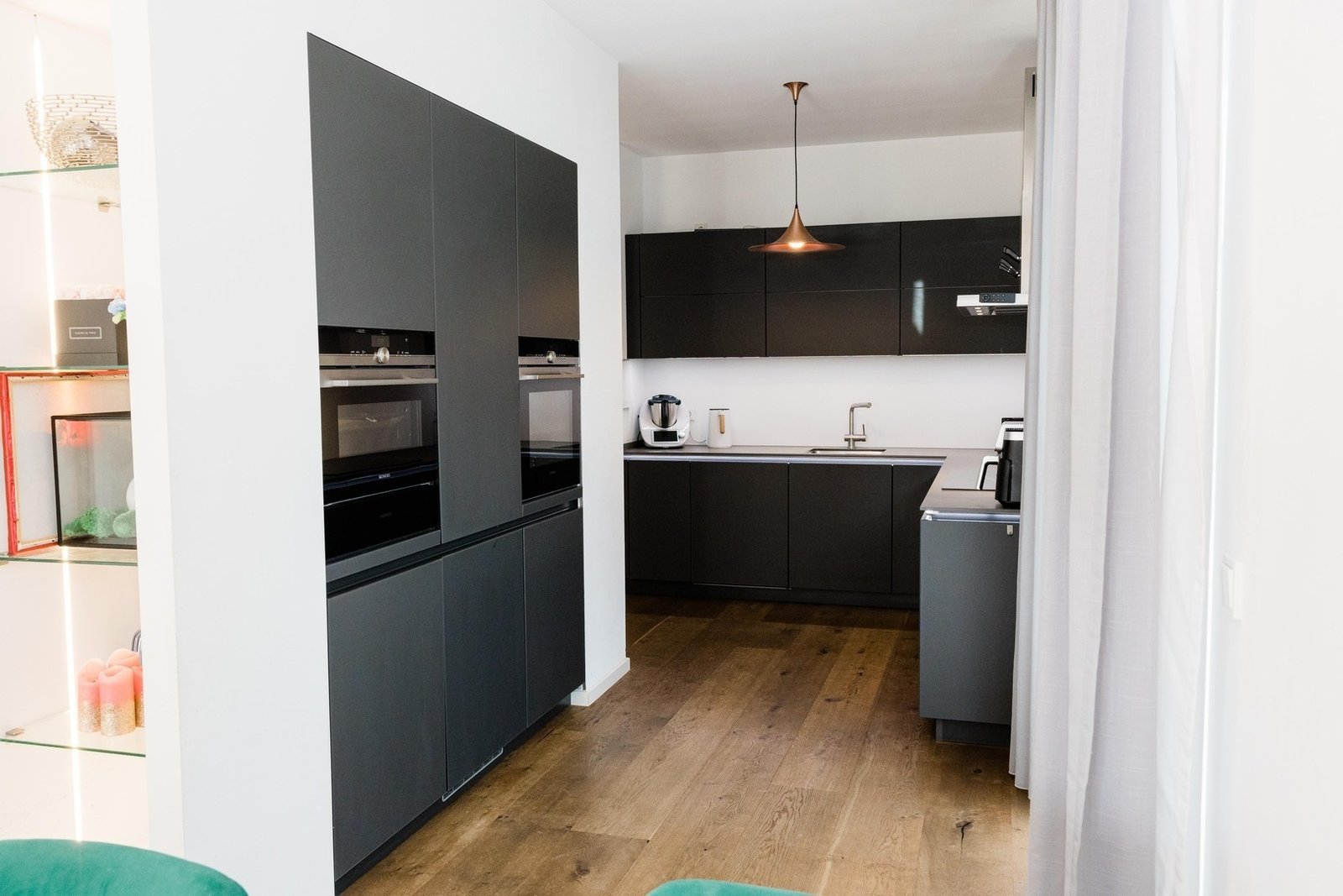 Dark fitted kitchen with light worktops