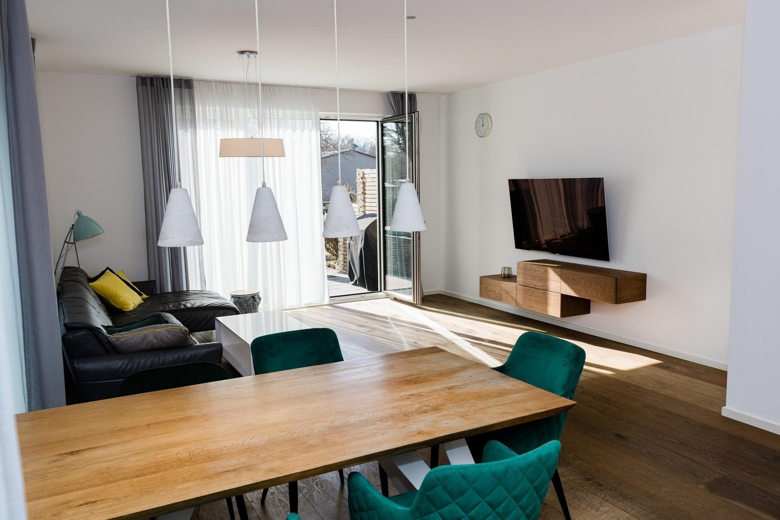 Open living and dining area with wood flooring and large windows
